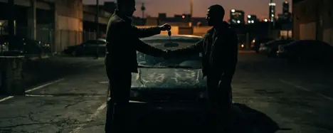 Schattenhafter Händedruck über Gebrauchtwagen bei Abenddämmerung mit Autoschlüsseln und Bargeld – Misstrauen beim Autokauf