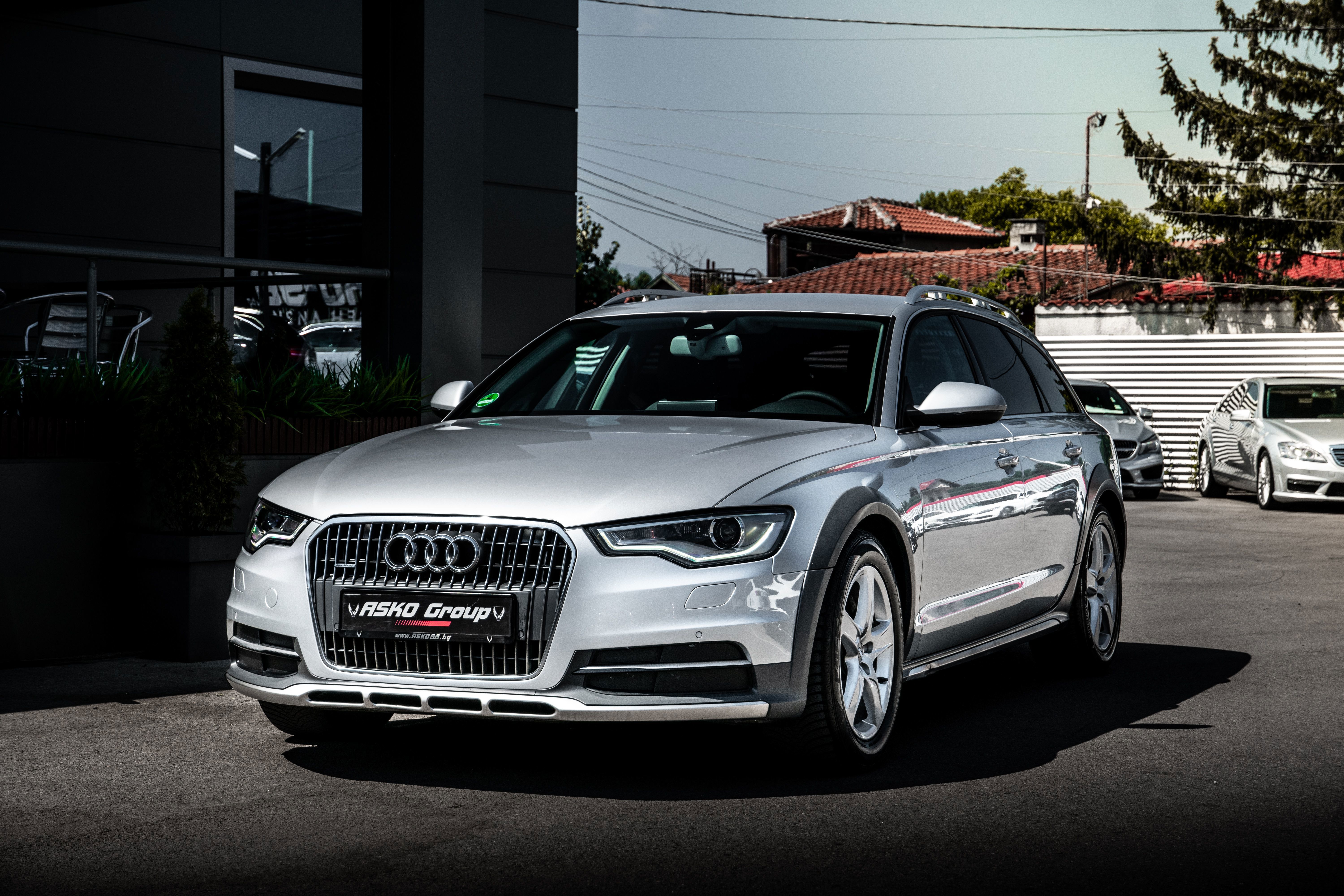 Audi A6 Limousine in Silber vor moderner Architektur