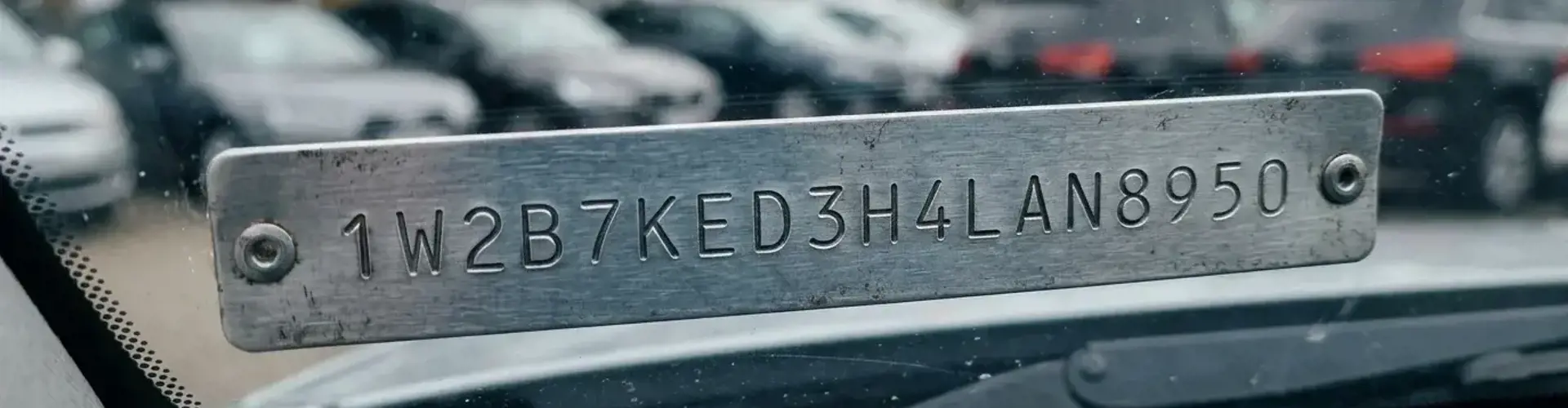Nahaufnahme der 17-stelligen Fahrgestellnummer hinter der Windschutzscheibe eines Fahrzeugs bei Tageslicht